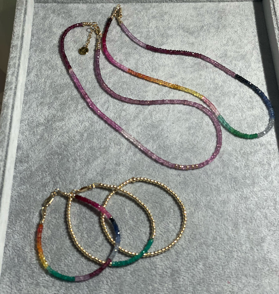 Multi emerald, sapphire and ruby "Tisissi" necklace and shades of pink sapphire with ruby strand. Also shown multi faceted gemstone bracelet with clasp, 3mm 14k gold filled beads with Columbian emerald band and clasp, 3mm 14k gold filled stretch.