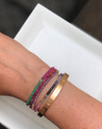 Stack of muti coloured natural precious stone bracelets with clasp.  Cartier  LOVE bracelet  clients own.