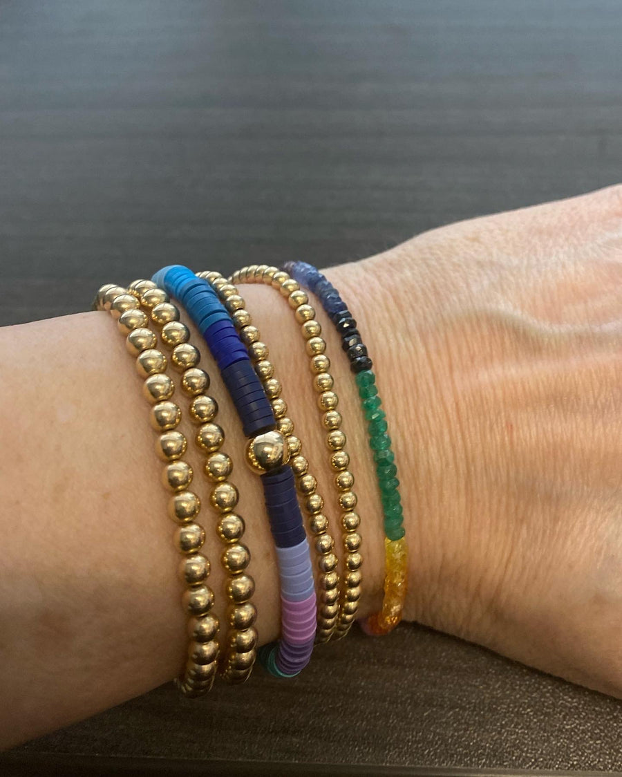 Left to right. - two 5mm 14k gold filled bracelets, rainbow heshi bracelet with 6mm gold filled bead in center, two 3mm 14k gold filled bracelets and all natural faceted stone rainbow bracelet. 