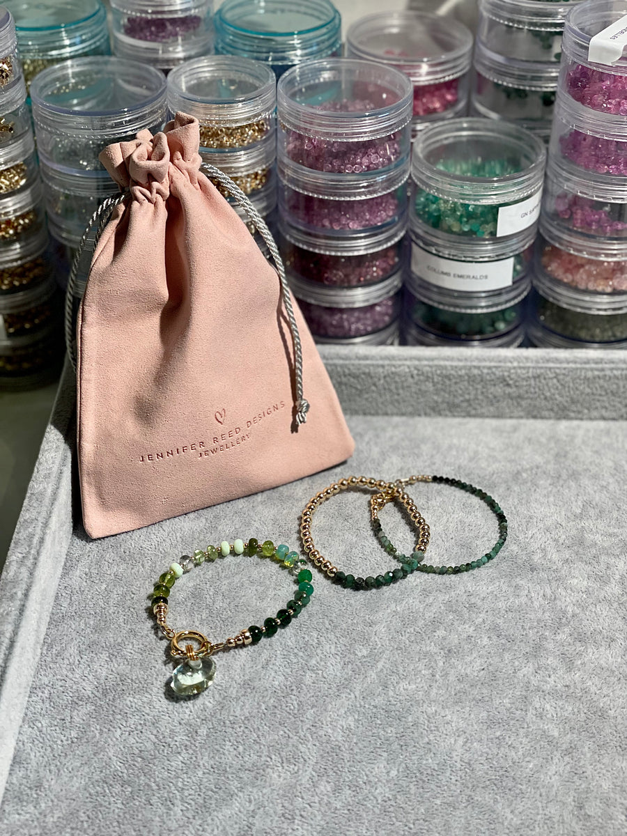 Mixed smooth shades of green gemstones with oversized clasp and translucent green amethyst hand carved cloud charm. Also shown 5mm gold filled beads with smooth emeralds and petite raw emerald bracelet.