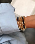 Stack of lapis lazuli and 14k gold filled stretch bracelets. left to right - 6mm lapis with band of 14k gold filled bracelet, 8mm 14k gold filled bracelet with scattered rondelles, 6mm 14k gold filled bracelet, 4mm lapis lazuli bracelet with scattered rondelles, 6mm 14k gold filled bracelet.
