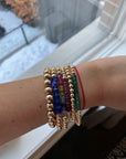 mixed stack. Left to right- 8mm 14k gold filled bracelet, 6mm with cobalt blue larger Swarovski crystal cubes, 5mm with rainbow Swarovski crystal cubes, 4mm with natural faceted rubies and clasp, 5mm 14k gold filled bracelet, 4mm 14k gold filled bracelet with opaque green Swarovski crystal beads.
