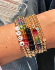 Left to right - 4mm 14k gold filled bracelet with glass alphabet letters "LOVE", 8MM with large rainbow Swarovski crystal cubes, 8mm with navy blue Swarovski crystal cubes, 3mm 14k gold filled bracelet with heart, 5mm 14k gold filled bracelet with rainbow Swarovski crystal beads, 4mm 14k gold filled bracelet with heart and 3mm 14k gold filled bracelet with 5 hearts.